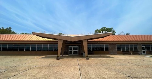 Exterior view of a building with a distinctive roof design, featuring large windows and a sign that reads "City Park."