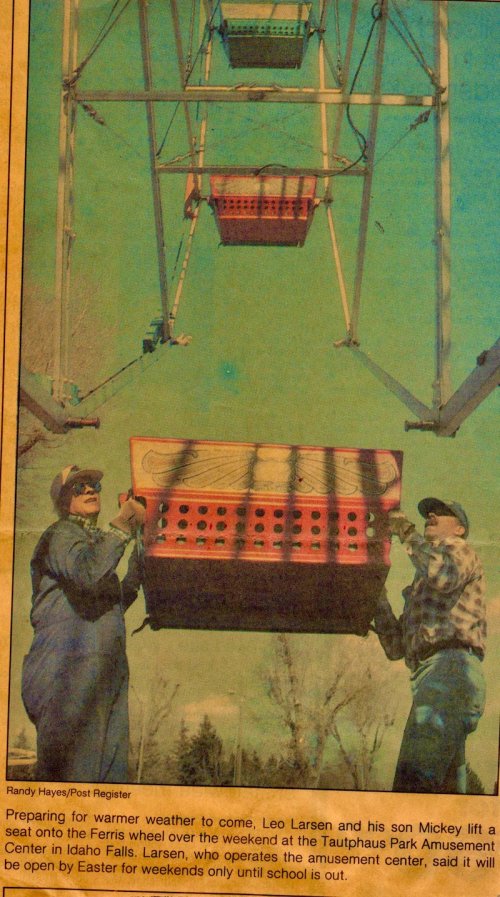 Two men lift a seat onto a Ferris wheel at Tautphaus Park Amusement Center in Idaho Falls, preparing for Easter.