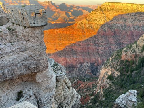 A stunning view of the Grand Canyon at sunset, showcasing layered rock formations and vibrant colors.