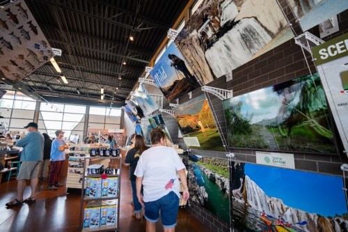 A spacious store interior featuring large nature photos on the walls, with customers browsing merchandise.