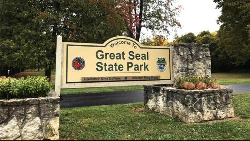 Welcome sign for Great Seal State Park, featuring park logos and surrounded by greenery.