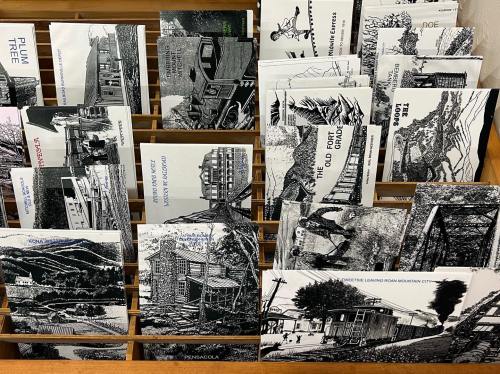 A display of black-and-white illustrated postcards featuring various landscapes and buildings.
