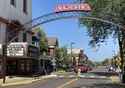 A street view featuring the Majestic theater marquee and archway, with trees and buildings lining the road.