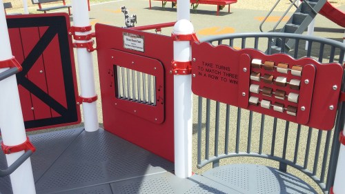 Playground structure featuring a game panel with a matching game and a small door for interactive play.