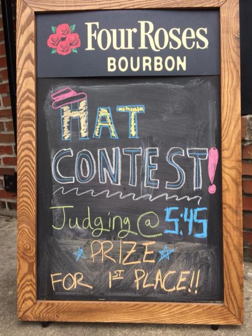 Chalkboard sign advertising a hat contest with judging at 5:45 PM and a prize for first place.