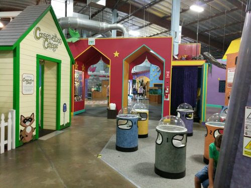 Colorful indoor play area with themed rooms and interactive exhibits, featuring playful structures and activity stations.