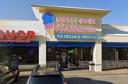 Exterior of "Sweet Cone Alabama" ice cream shop, featuring a colorful sign and an open sign in the window.