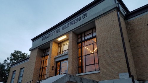 Exterior of Halpatter Brewing Co. building with large windows and a welcoming entrance.