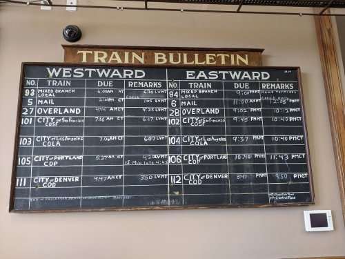 Train bulletin board displaying schedules for westbound and eastbound trains, including train numbers, due times, and remarks.