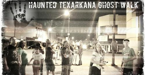 A group of people gathered on a street at night for the Haunted Texarkana Ghost Walk, with a spooky atmosphere.