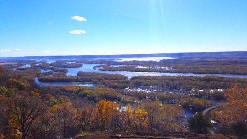 A scenic view of winding rivers surrounded by autumn foliage under a clear blue sky.