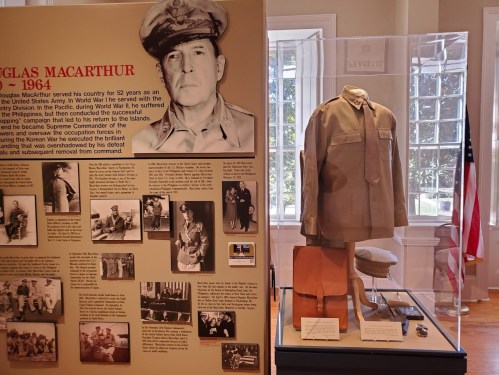 Exhibit featuring a display about Douglas MacArthur, including a uniform and historical photos.