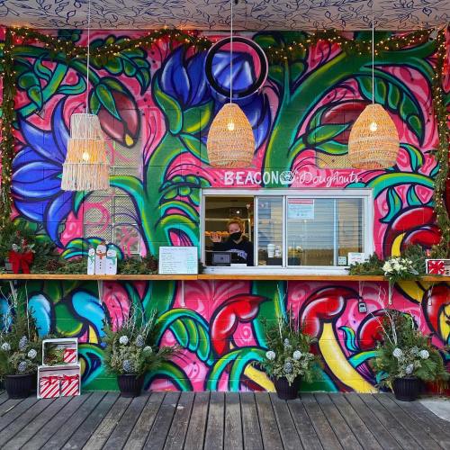 Colorful mural backdrop with a donut stand, featuring hanging lights and festive decorations.