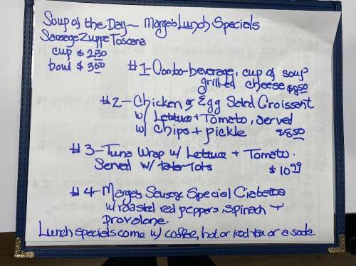 Menu board listing lunch specials: soup, salads, wraps, and beverages with prices.