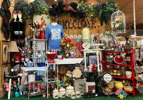 A colorful display of vintage items, including decor, clothing, and kitchenware, arranged on shelves and tables.
