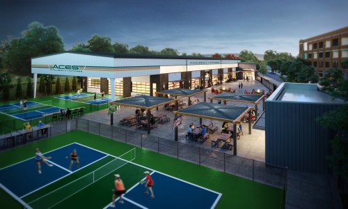 Aerial view of a sports facility with tennis courts, outdoor seating, and a modern building at dusk.