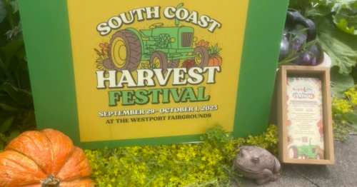 Sign for the South Coast Harvest Festival, featuring a tractor graphic, dates, and a decorative display of pumpkins and plants.