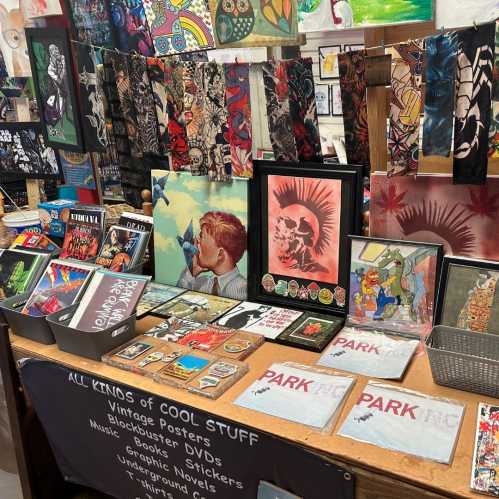 A vibrant display of vintage posters, art prints, stickers, and various collectibles on a table at a market.