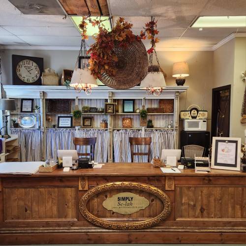 A cozy reception area with wooden decor, autumn decorations, and a vintage clock on the wall.