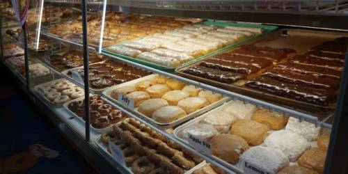 A display case filled with various donuts, including glazed, chocolate-covered, and filled options.