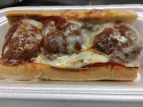 A meatball sub with three meatballs, marinara sauce, and melted cheese on a toasted hoagie roll.