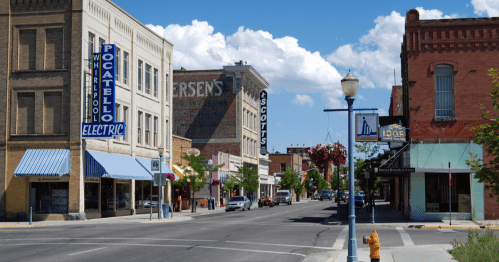 A sunny street view of downtown Pocatello, featuring historic buildings and storefronts under a blue sky.
