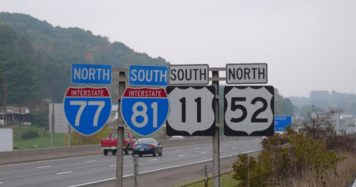 Interstate highway signs indicating directions for I-77 North, I-81 South, and US Route 11/52 North.