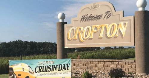 Welcome sign for Crofton with a banner promoting Cruisin' Day car show, grill fest, and live music.