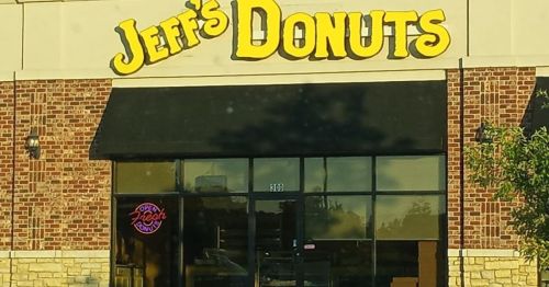 A storefront with a sign reading "Jeff's Donuts" and a neon "Open" sign in the window.