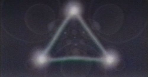 Abstract image featuring a blurred triangle formed by three glowing orbs against a dark background.