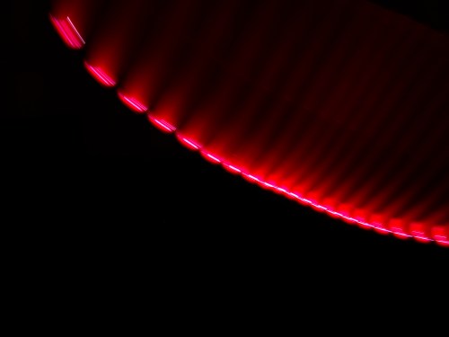 Abstract image featuring a curved line of vibrant red light against a dark background.