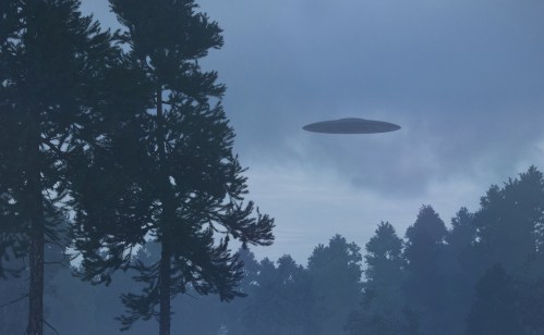 A UFO hovers above a misty forest, surrounded by tall trees and a cloudy sky.