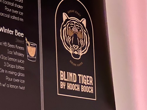 A menu featuring a tiger logo and the drink "Blind Tiger" by Hooch Booch, with cocktail preparation details.