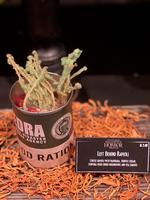 A can labeled "Food Ration" contains cheese ravioli, tempura fried enoki mushrooms, and pea shoots, surrounded by orange petals.
