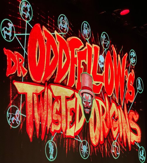 Colorful graphic featuring the text "Dr. Oddfellow's Twisted Origins" with a clown face and various spooky symbols.