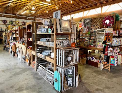 A rustic shop interior filled with wooden displays, crafts, and decor items, showcasing a cozy, inviting atmosphere.