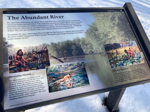 Sign about the Mississippi River's history, featuring illustrations of wildlife and early human activity along the river.