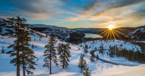 The sun peeks through the clouds over Donner Lake in Northern California on a winter day.