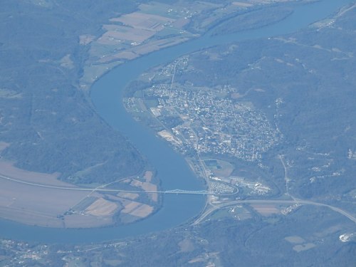Aerial view of a winding river surrounded by fields and a small town nestled along the banks.