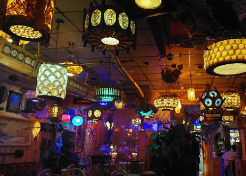 A vibrant interior filled with various decorative lamps and lights, creating a warm, eclectic atmosphere.