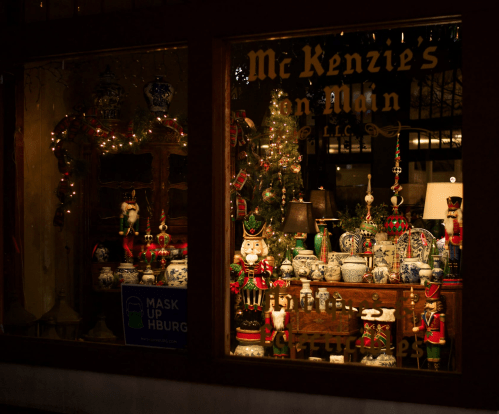 A festive shop window display featuring decorative items, nutcrackers, and holiday lights.