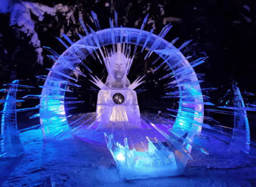 An illuminated ice sculpture surrounded by sharp, crystal-like formations, creating a magical winter scene.