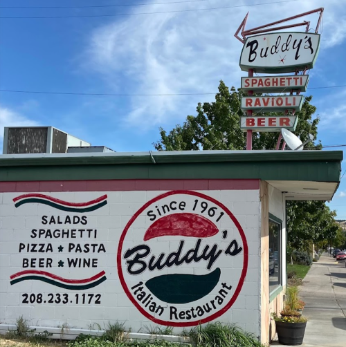 A colorful exterior of Buddy's Italian Restaurant, featuring a sign with menu items and a retro-style logo.