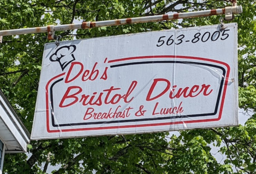 Sign for Deb's Bristol Diner, featuring "Breakfast & Lunch" with a chef's hat graphic and contact number 563-8005.