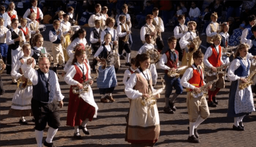 A lively parade featuring a group of musicians in traditional costumes playing instruments.