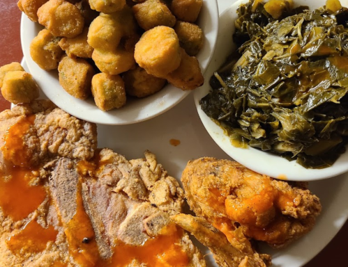 A plate of Southern comfort food featuring fried chicken, collard greens, and fried okra.