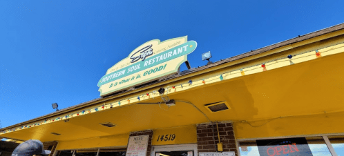 Sign for "Southern Soul Restaurant" with a bright yellow exterior and clear blue sky above.