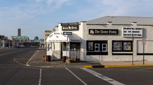 The Stone Pony, a famous music venue, stands on a quiet street with a clear sky in the background.