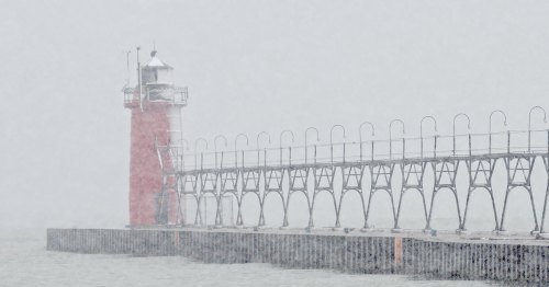 A red lighthouse stands on a foggy pier, surrounded by mist and waves, creating a serene yet eerie atmosphere.