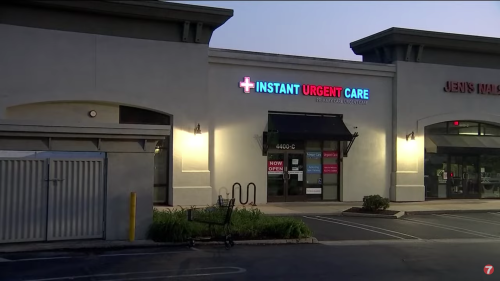 Exterior of an urgent care facility with a bright sign reading "Instant Urgent Care," located in a shopping plaza at dusk.